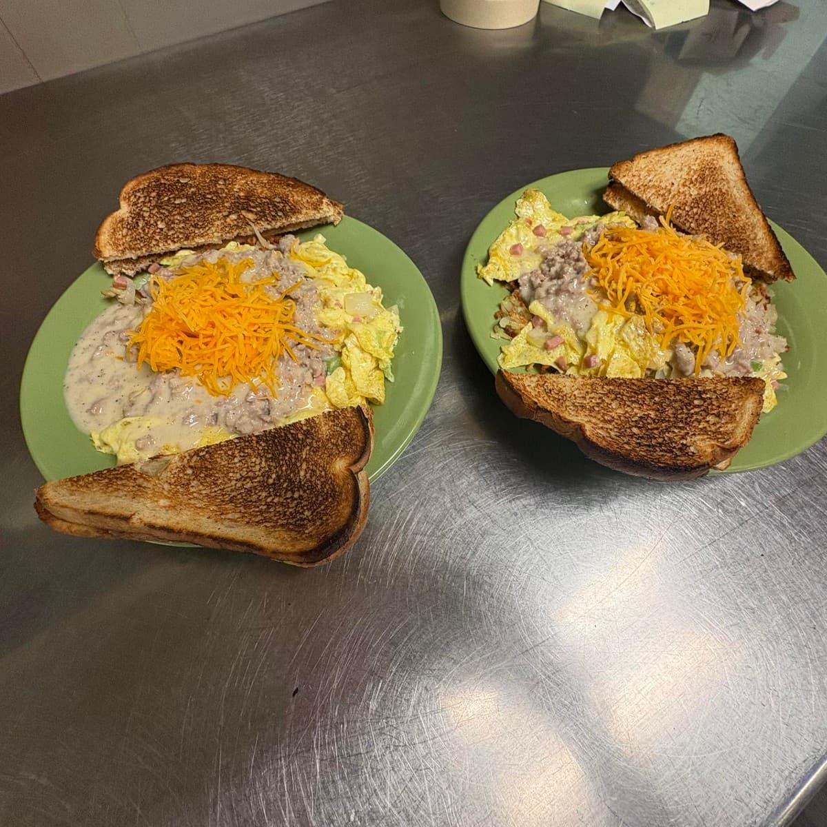 Breakfast Bowl — Scrambled eggs, ham, home fries, green peppers and onions, finished with sausage gravy and cheddar. Toast included